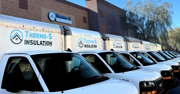 Thermo-S insulation franchise service trucks lined up outside facility, representing home insulation services