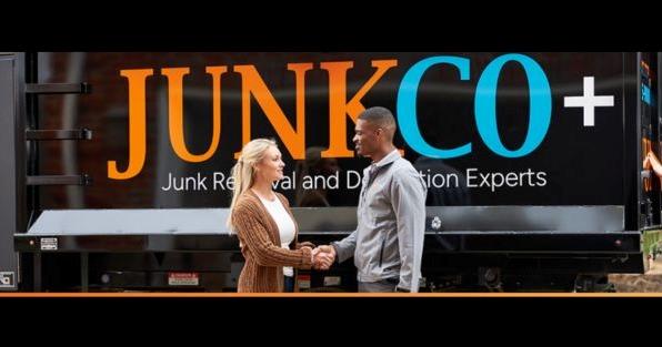 JUNKCO+ junk removal and demolition team handshake in front of branded truck, highlighting Las Vegas franchise expansion