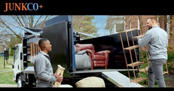 JUNKCO+ franchise team loading furniture into junk removal truck, highlighting demolition and cleanout services