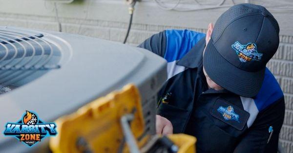 Varsity Zone franchise HVAC technician servicing air conditioning unit, highlighting residential HVAC repair and maintenance