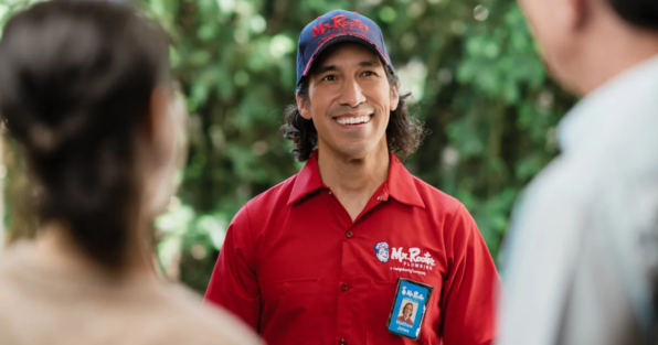 Mr. Rooter franchise plumber greeting homeowners, highlighting residential and commercial plumbing services