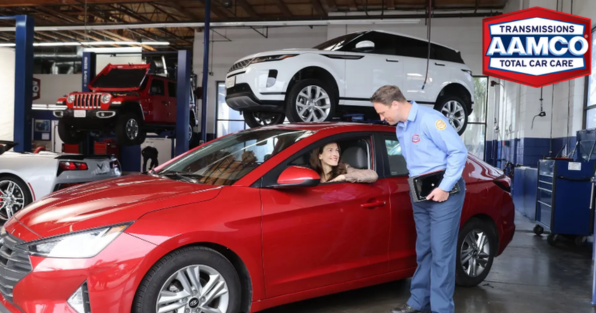 AAMCO franchise technician assisting customer at auto repair shop, highlighting transmission and total car care services