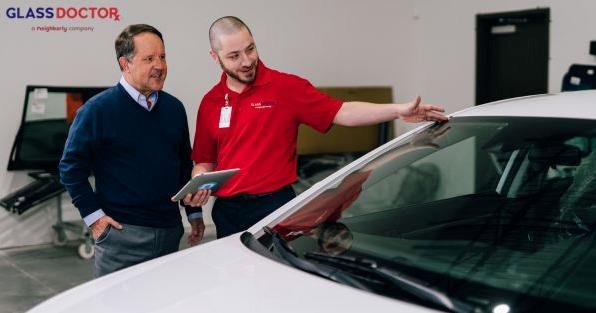 Glass Doctor franchise featuring an automotive glass specialist discussing windshield repair and replacement services with a customer