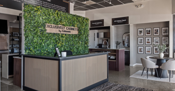 Exclusively Cabinets showroom with branded green wall and reception desk, modern cabinetry retail franchise in Pittsburgh