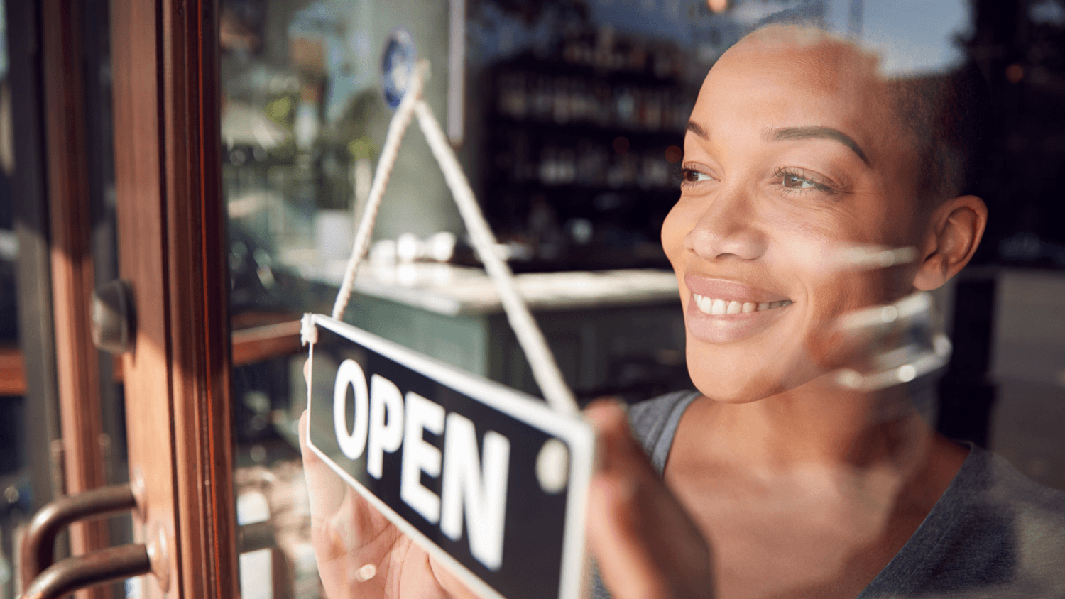 Prospective franchise owner holding an open sign at a business