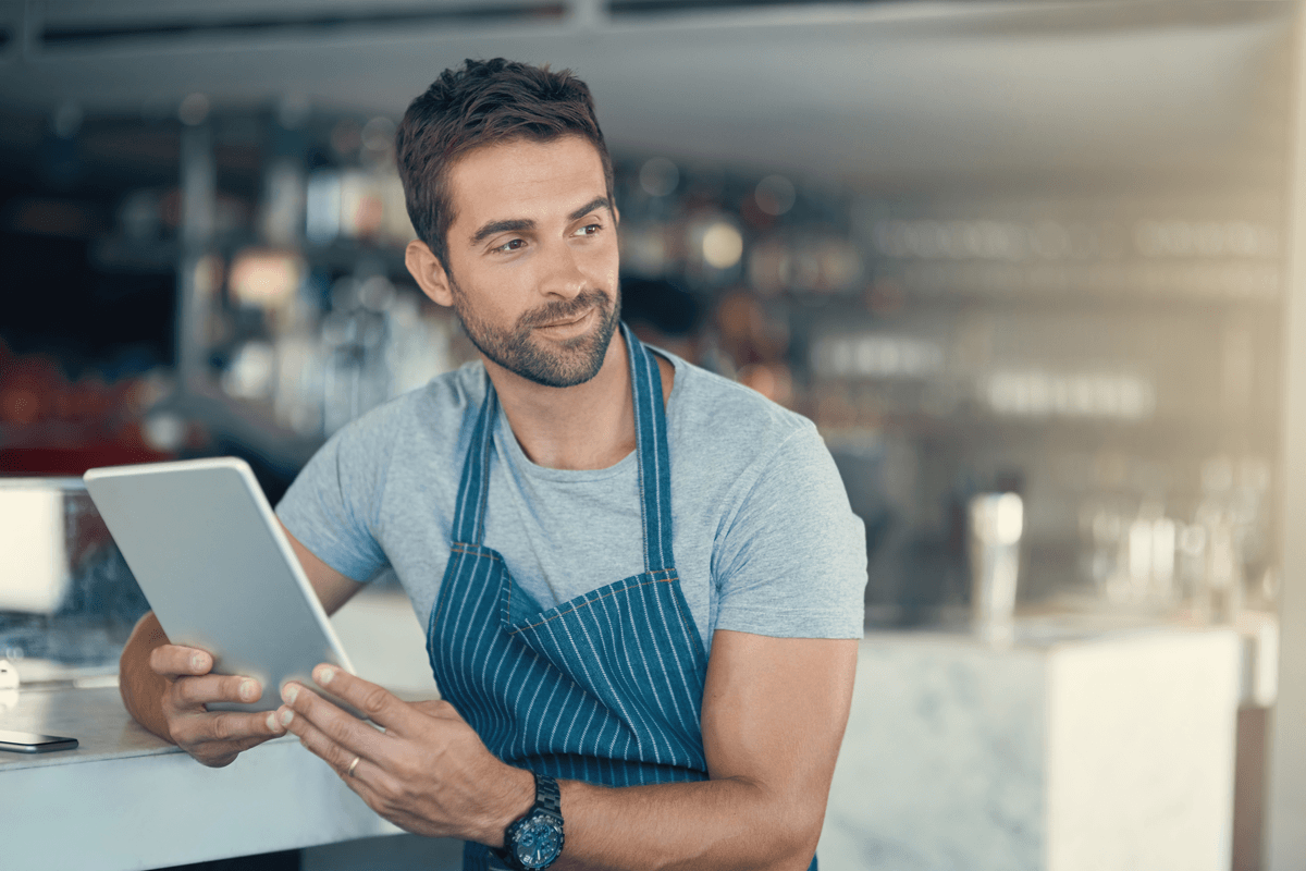 Successful franchise owner using a tablet at his business